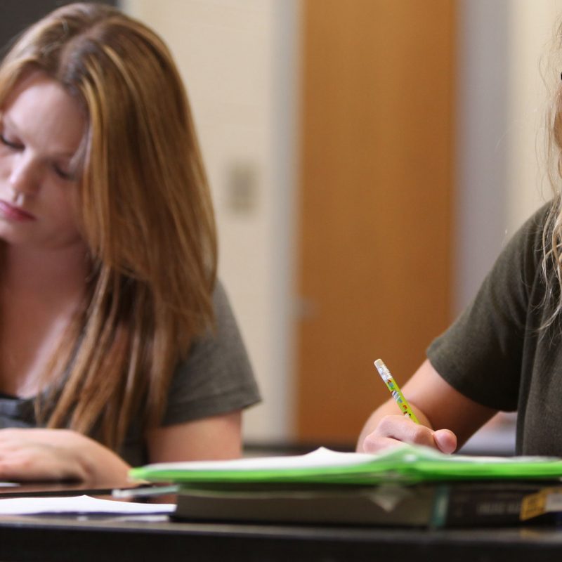 Two female students taking notes