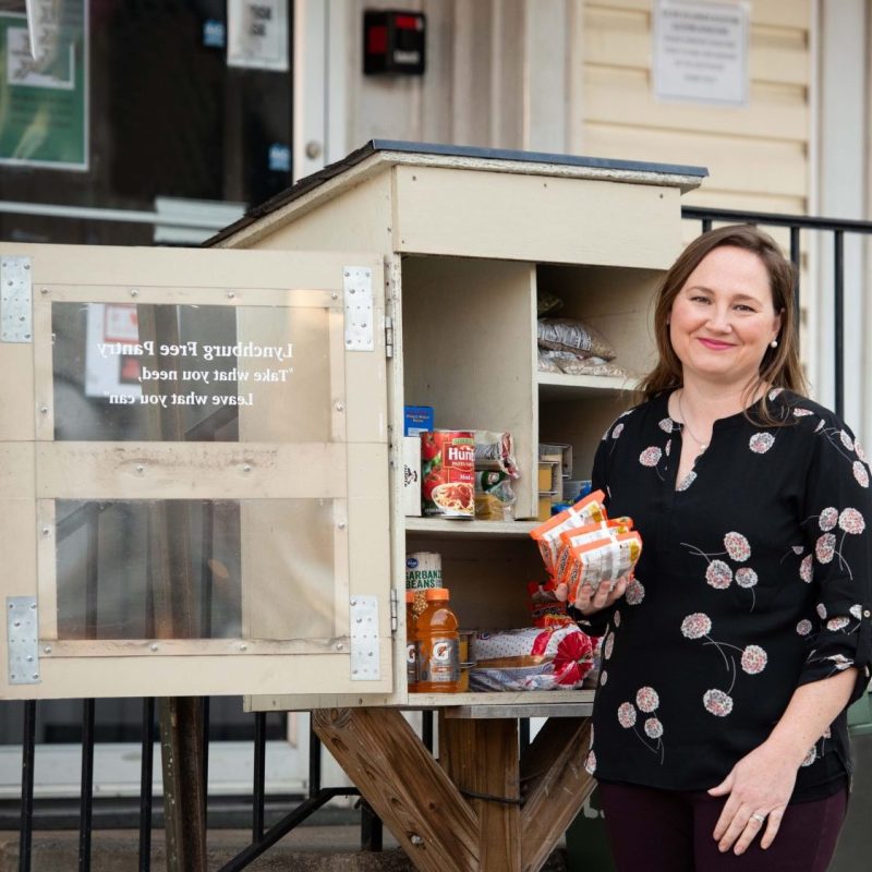 Megan Huffman poses in front of a small community food pantry
