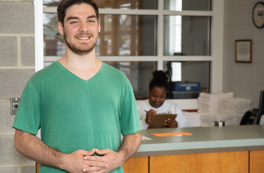 Lane Salisbury standing in front of counter with a green shirt