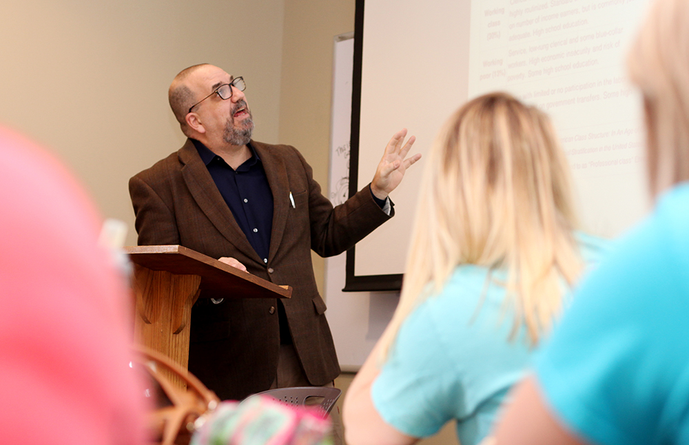 Professor pointing to displayed projector in class