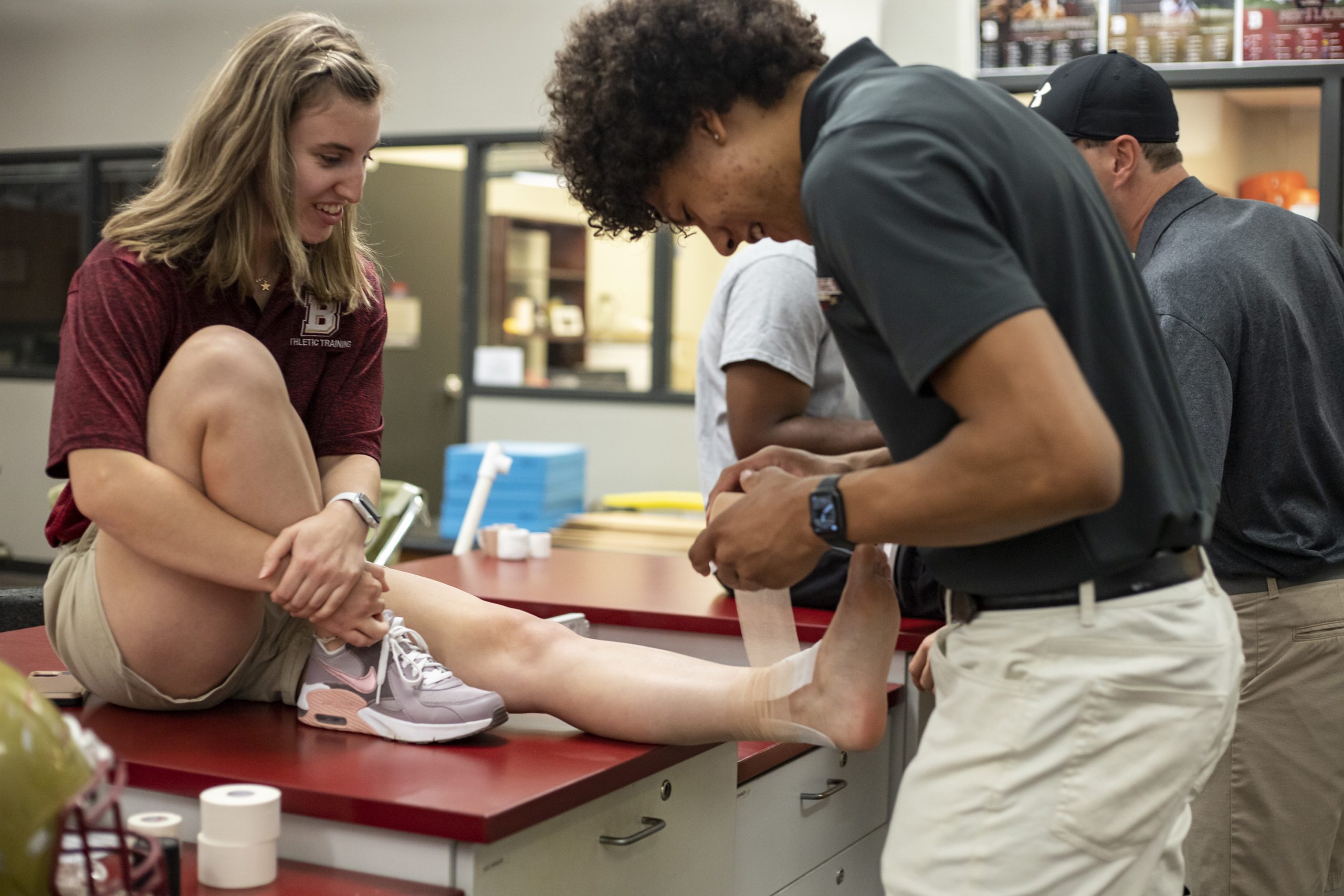 Athletic training student practicing taping ankle