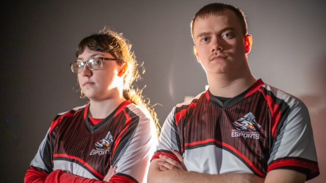 Two esports players looking at camera with serious expression and crossing their arms