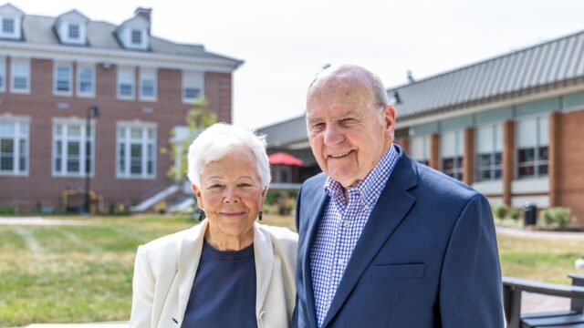 A photo of Rev. Wilfred Nolen and Dr. Joyce Nolen standing side-by-side smiling outside on Rebecca Quad