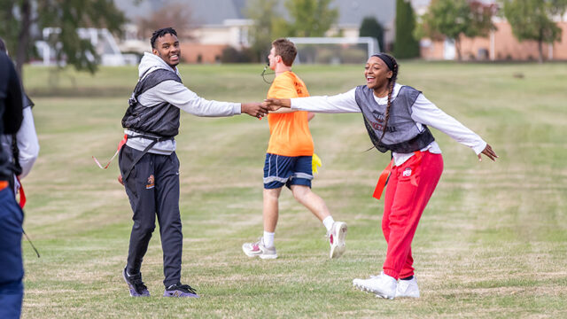 Boy and girl high-fiving during a flag football