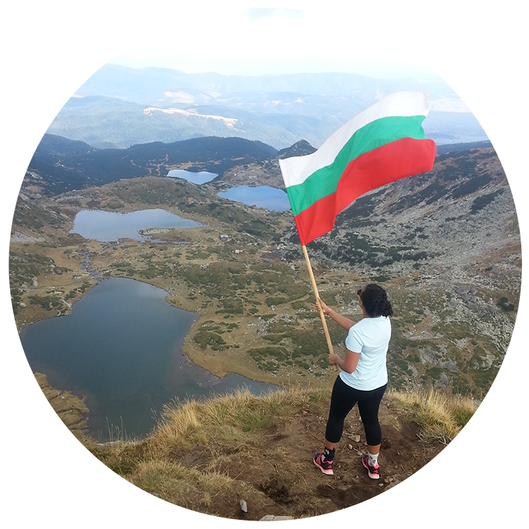Student waving large Bulgarian flag over a lake