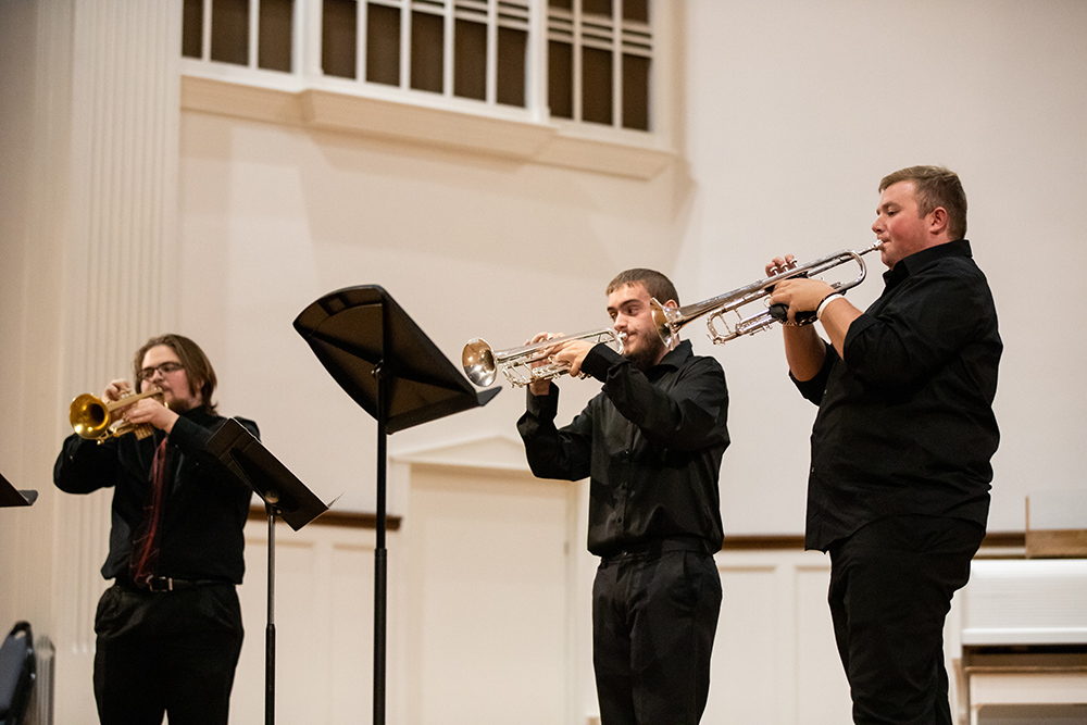 Three band members playing trumpets