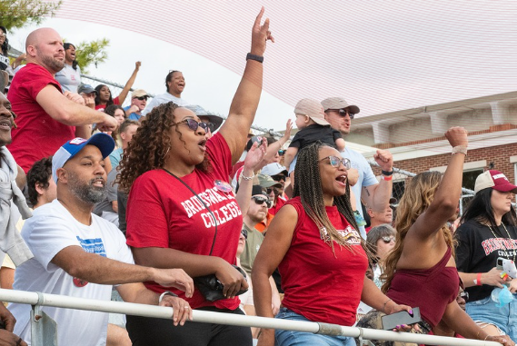 Fans wearing Bridgewater College tshirts cheering during football game