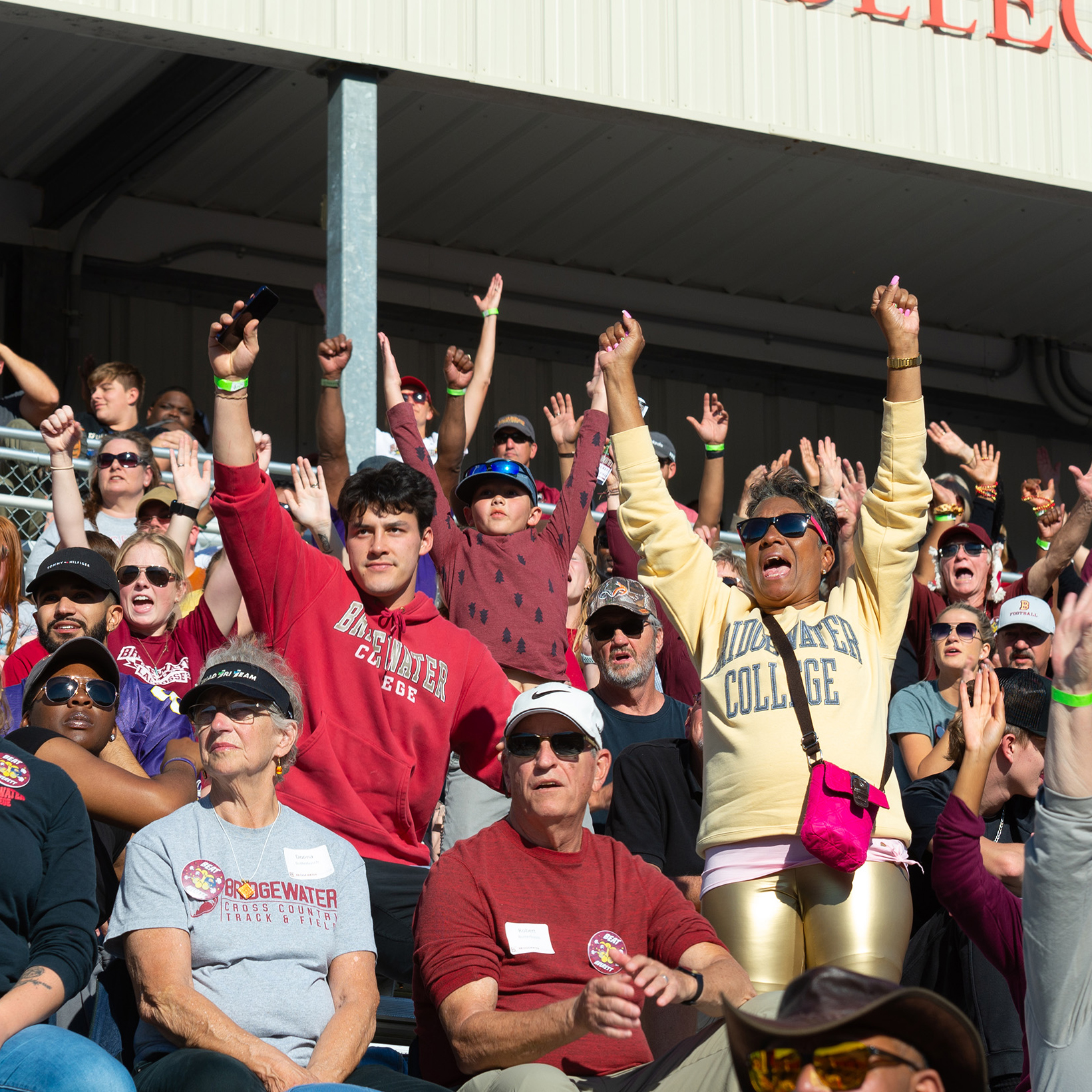 Fans standing up cheering during football game