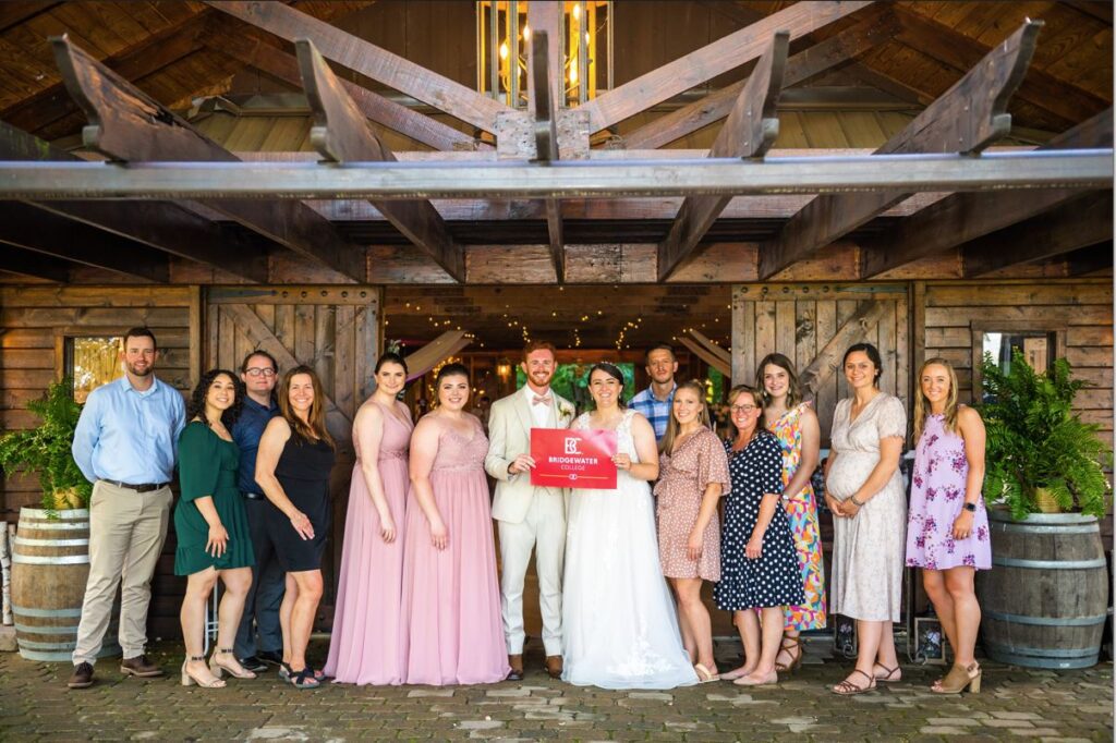 Group of B-C alumni at a wedding holding the B-C wedding box banner