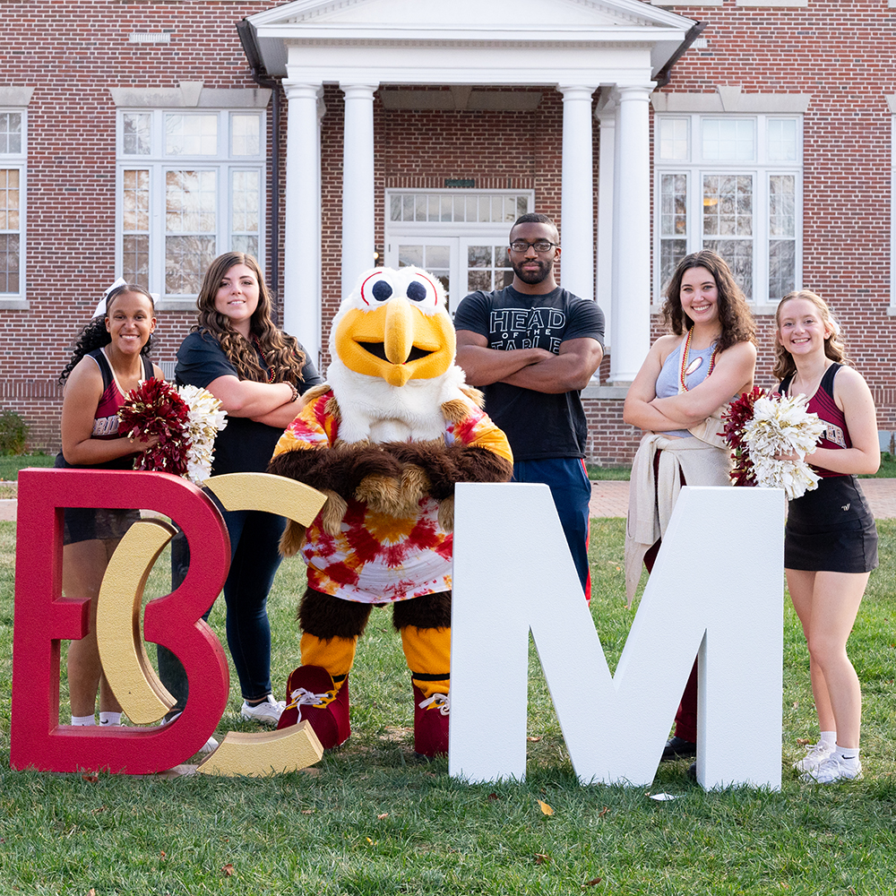 Cheerleaders B-C students and mascot Ernie posing in front of B-C Homecoming letters