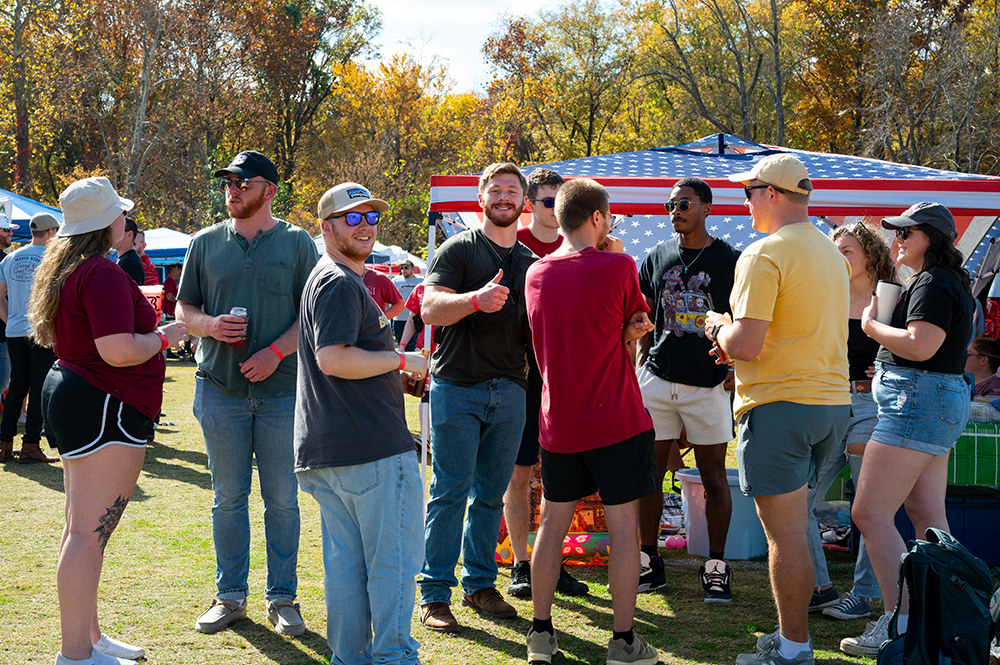 Group of people during tailgate. One guy is giving thumbs up