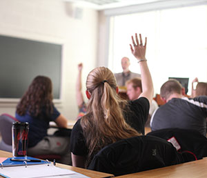 Back of student raising hand in class