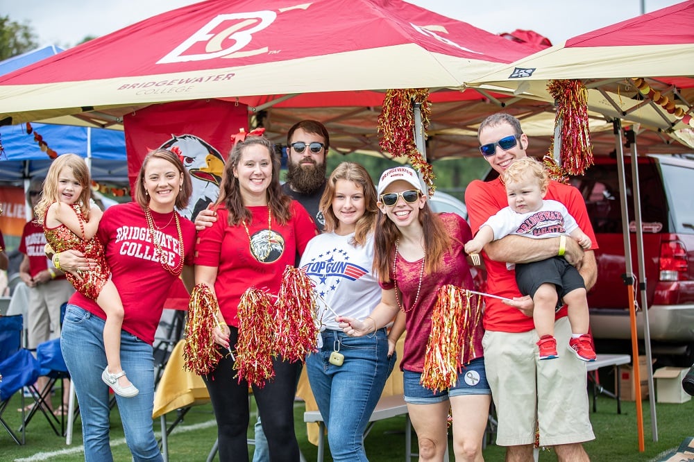 Group of adults and children showing Bridgewater spirit standing in front of Bridgewater College canopies