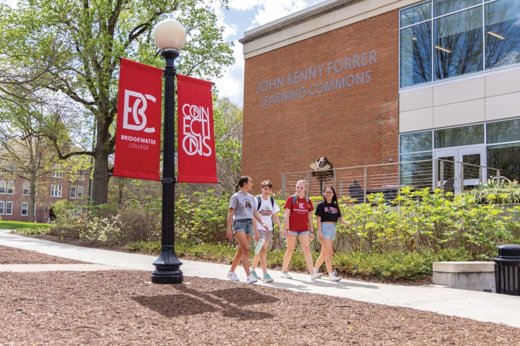 Three students walk to the FLC on a warm spring day.