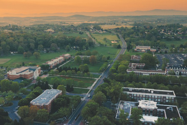 Sunset drone shot of Bridgewater College campus when grass is green 