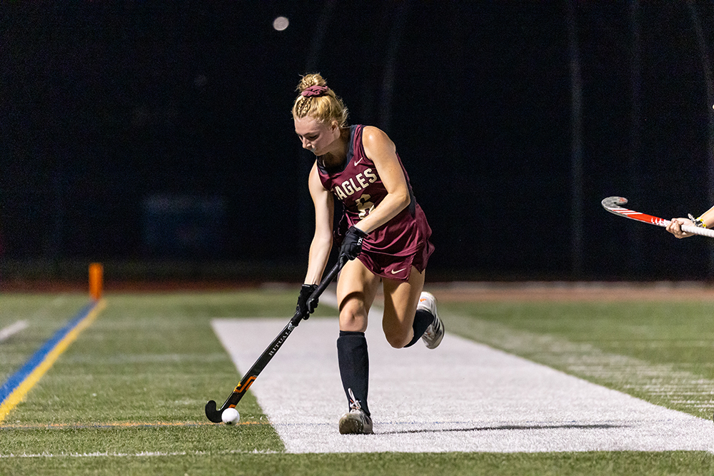 Field hockey player on turf field at night