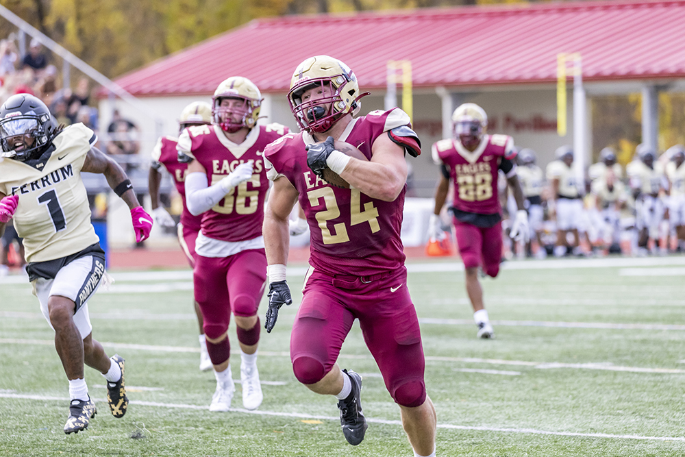 Number 24 running with the ball during football game