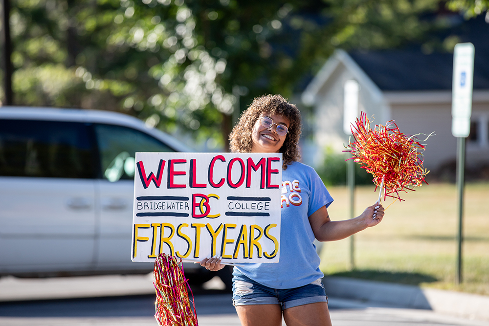 Autumn Sissler holds welcome sign.