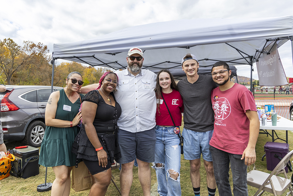 Group of students gathered with professor at homecoming tailgate