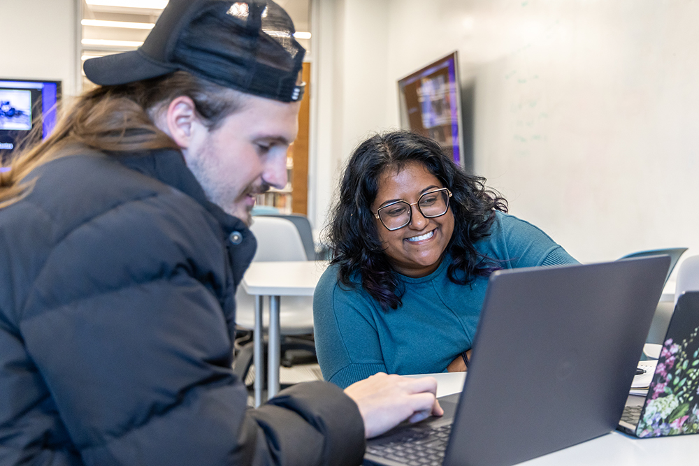 Two students looking at a laptop