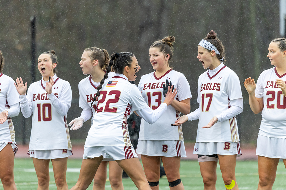 Line of women's lacrosse players high fiving before a game