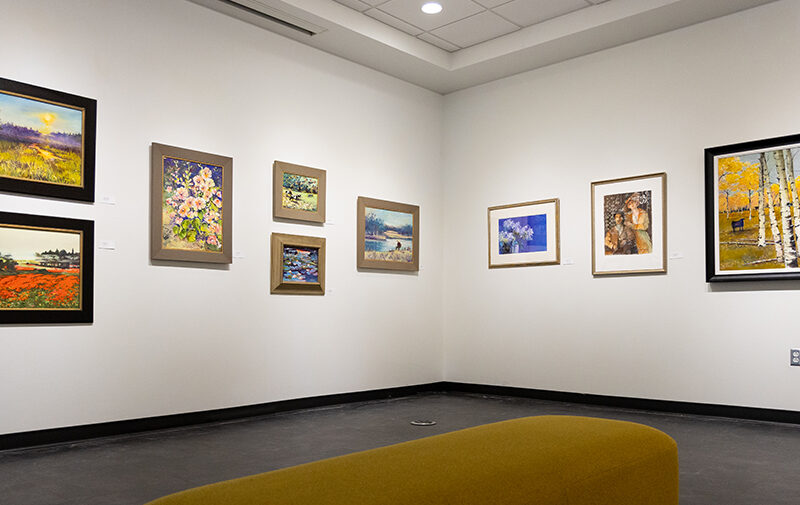 Paintings displayed on the white walls of the Beverly Perdue Art Gallery