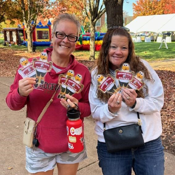 Women holding up Flat Ernie's they found on the Bridgewater College campus