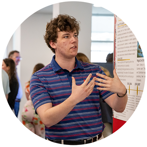 Student in blue striped polo speaking with this hands