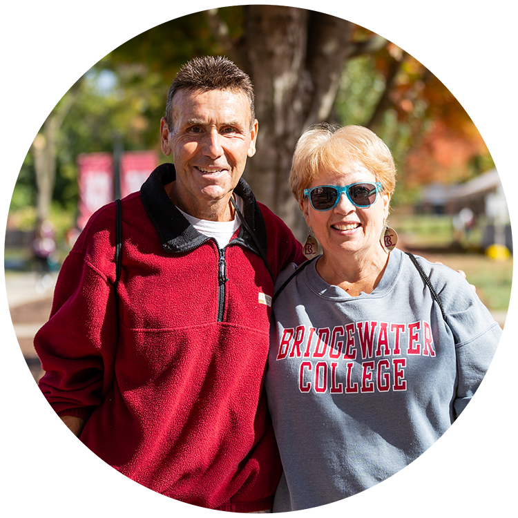 Man and a woman smiling for photo at homecoming