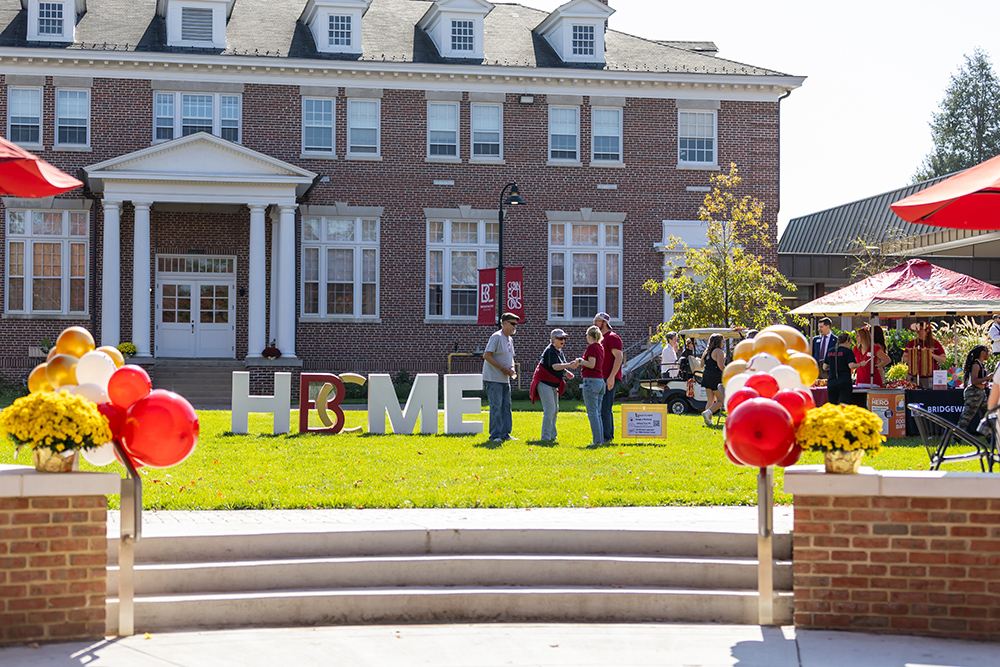 People standing in front of B-C Home letters on the Rebecca Quad at Homecoming