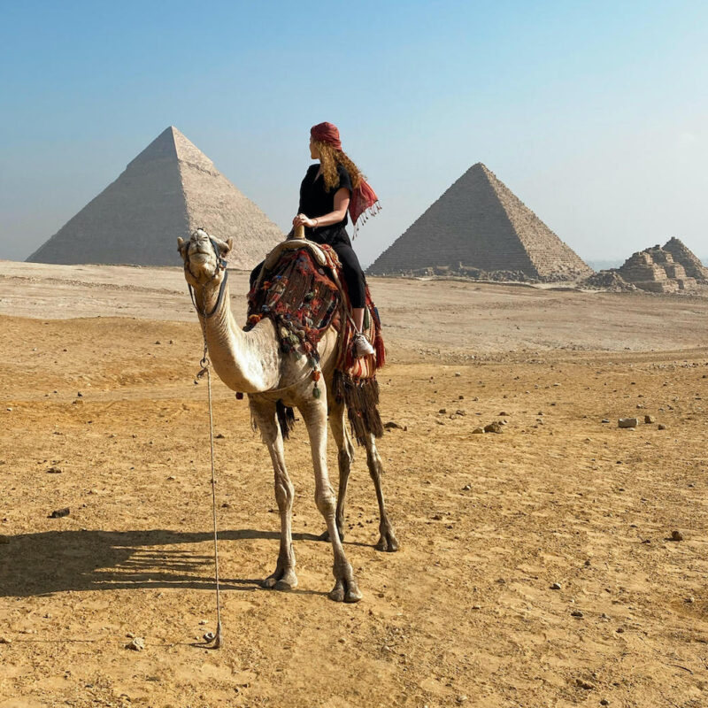 Study abroad participant in Egypt with pyramids in background.