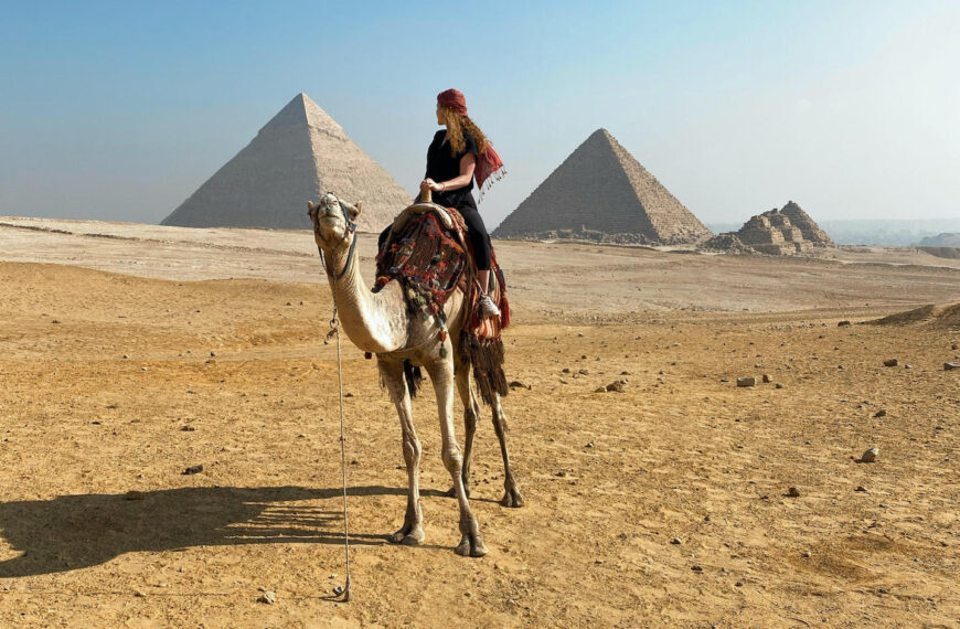 Study abroad participant in Egypt with pyramids in background.