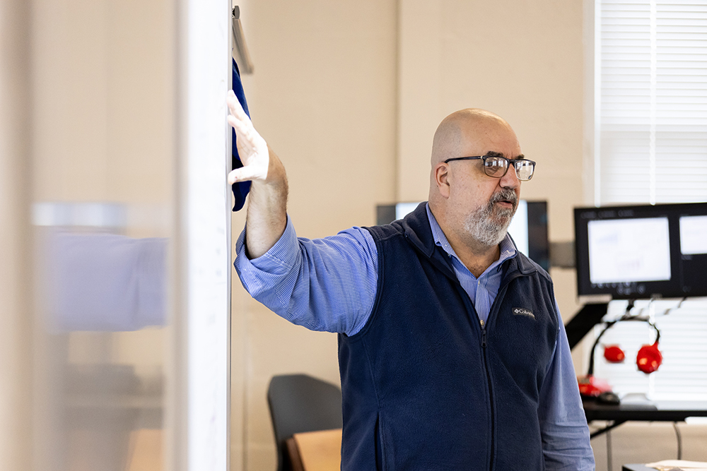 Dr. Skip Burzumato pointing to the board in class