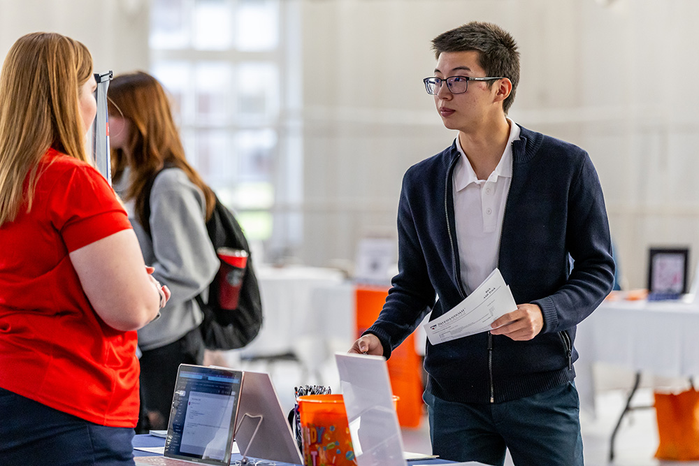 Student speaking with a woman at the career fair