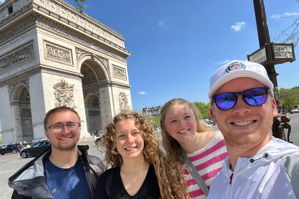 Students taking a selfie in front of the Arc de Triumph in Paris