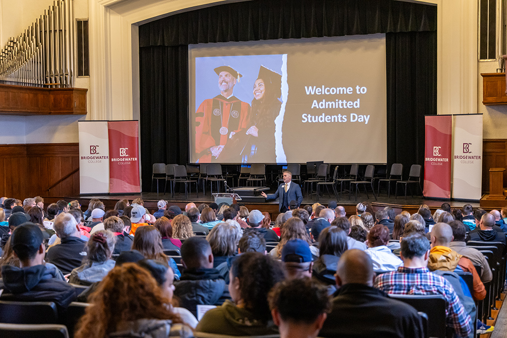 Cole Hall full of people during Admitted Students Day with the projector screen reading Welcome to Admitted Students Day