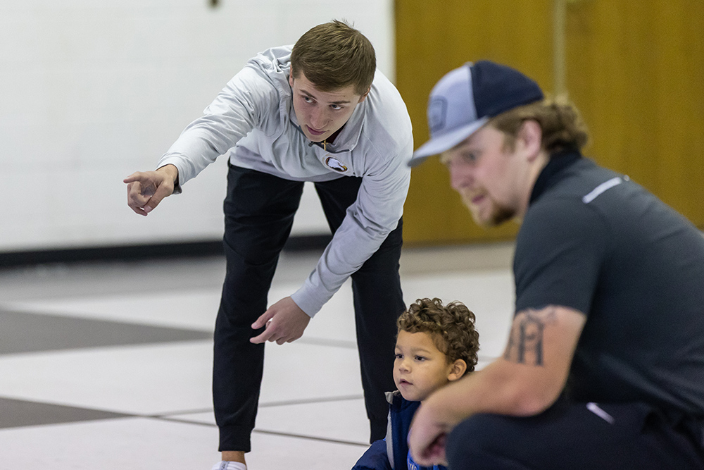 Student pointing out something to a young kid during a P.E. class