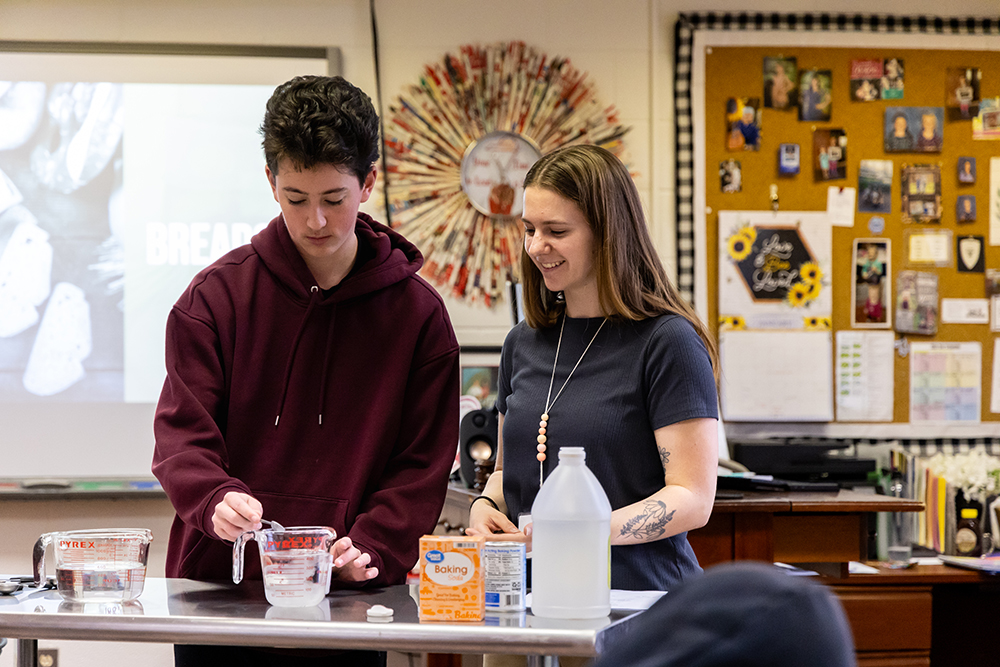 Student teacher working with student in a classroom