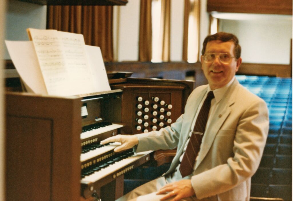 Portrait of Dr. John Barr sitting at the organ console in Cole Hall