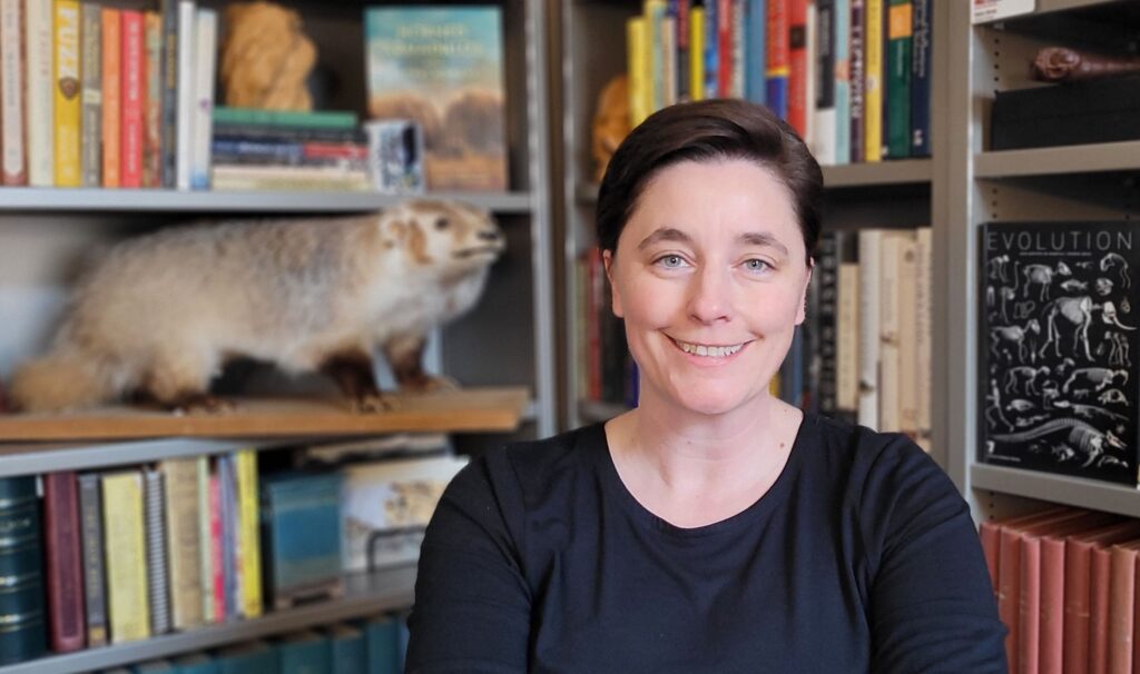 Dr. Katie Hinde in front of bookshelves