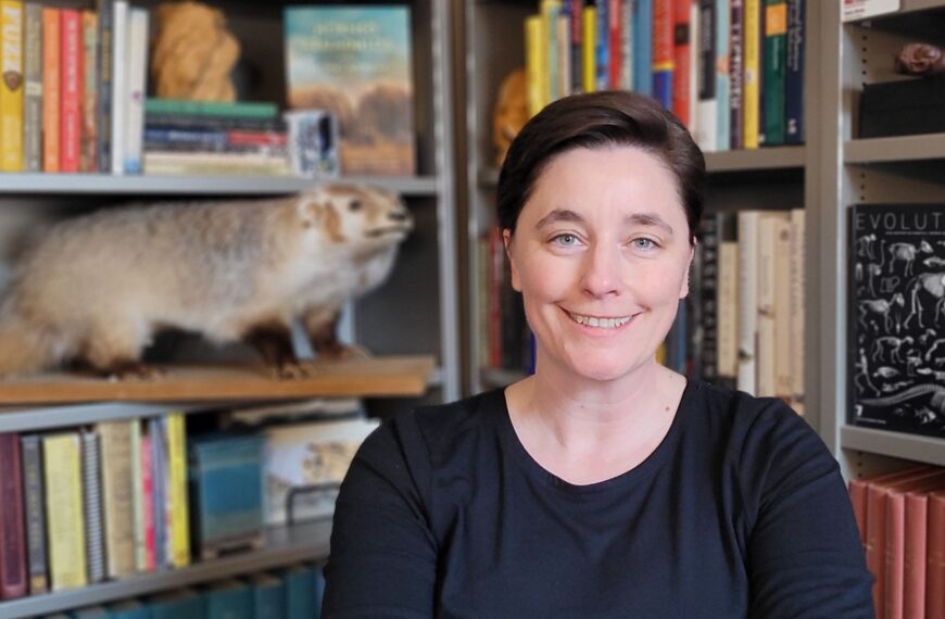 Dr. Katie Hinde in front of bookshelves