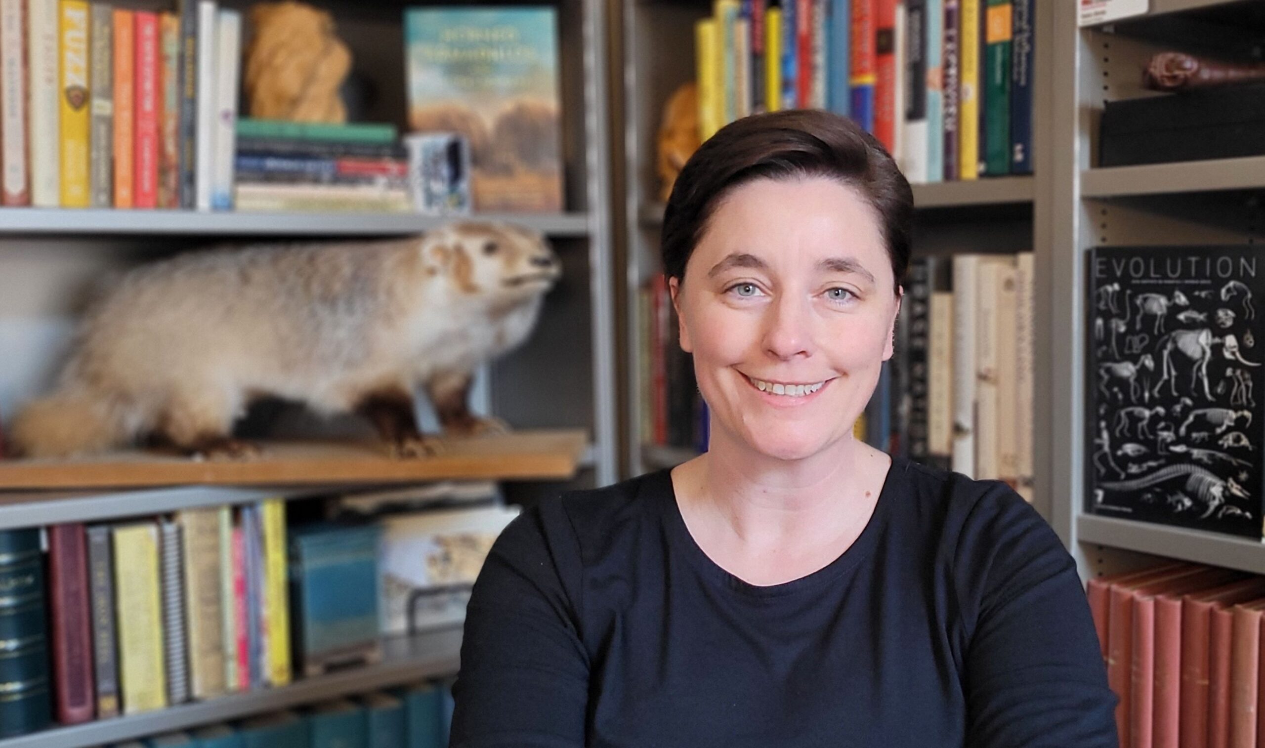 Dr. Katie Hinde in front of bookshelves