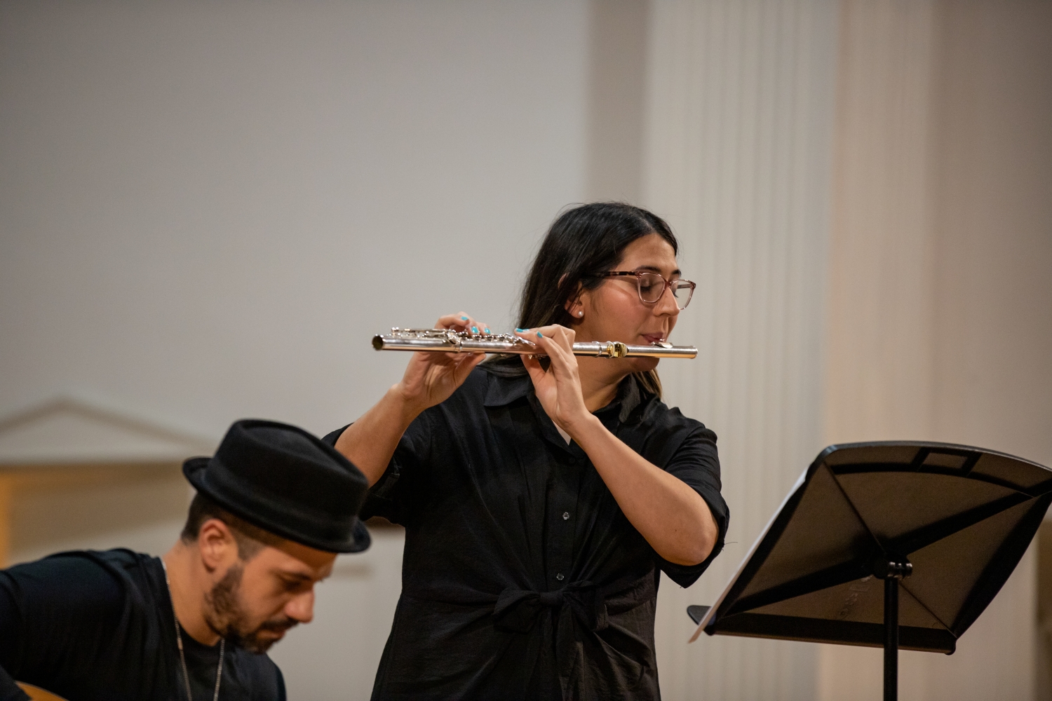 Dr. Colon playing flute on stage in Carter Hall