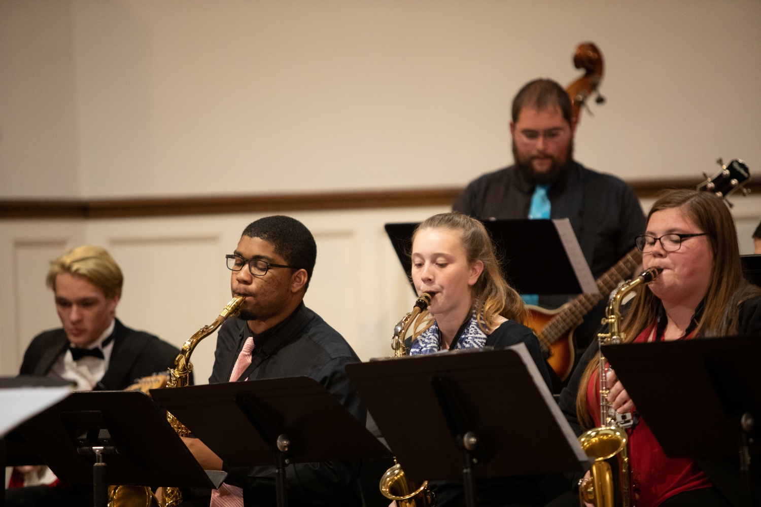 Three saxophone players focus on their music