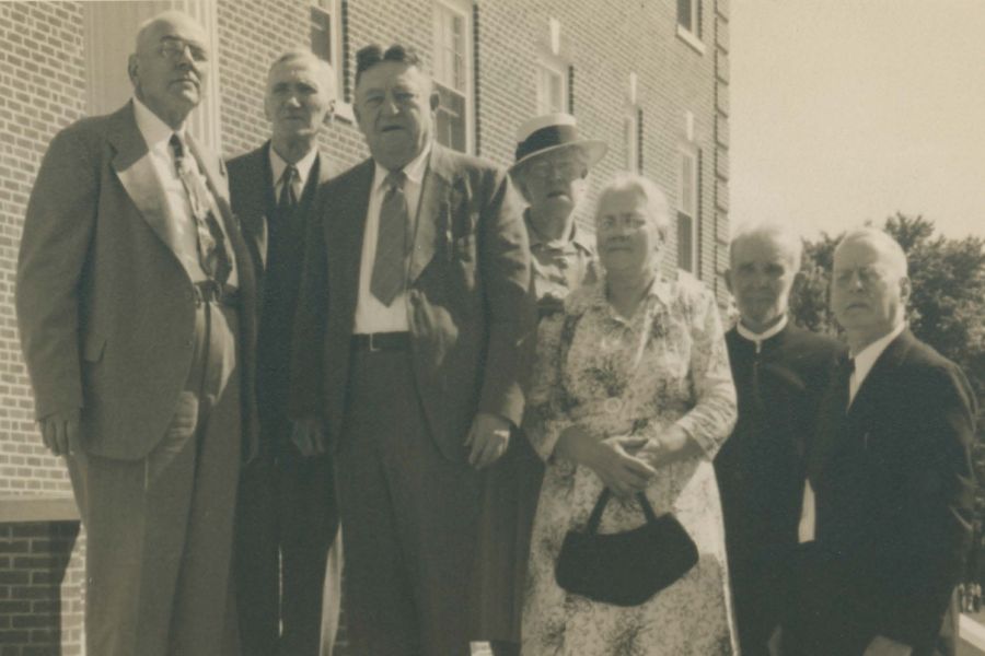 Group of seven alumni from the Class of 1899 standing on stairs.