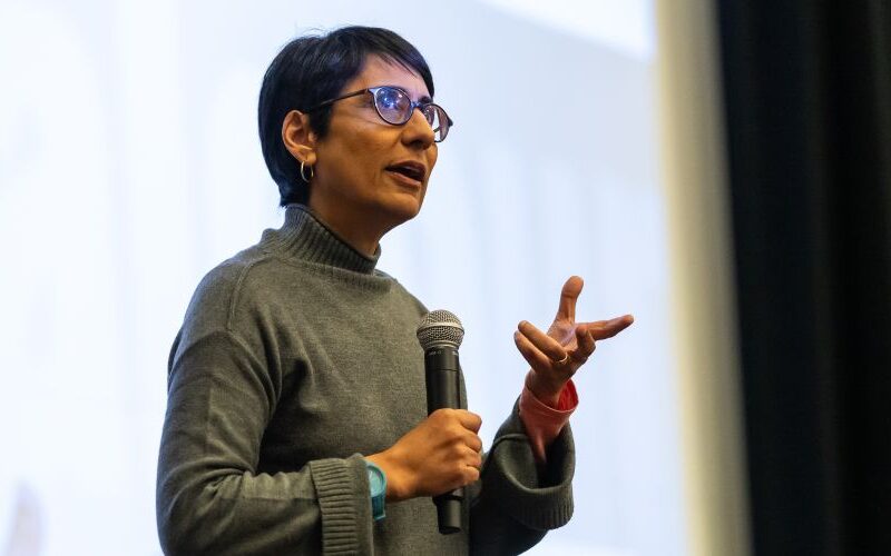 Irshad Manji speaks fervently in front of a screen
